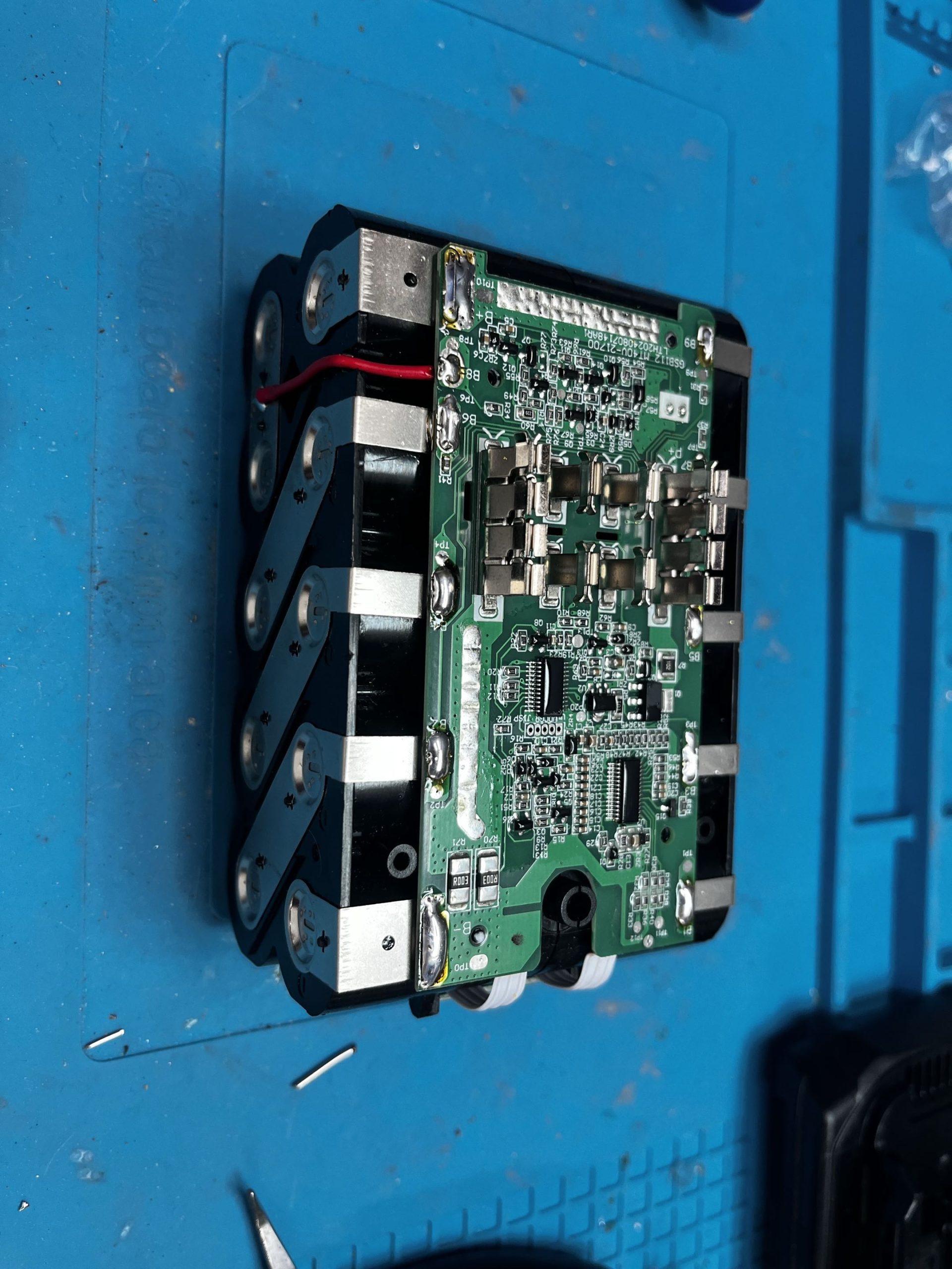 BMS board mounted on cell pack with red charge wire connected