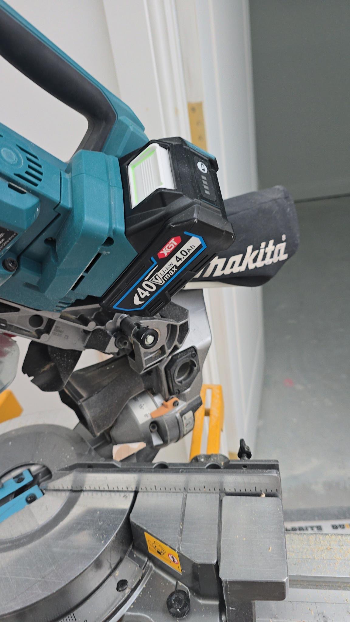 DIY Makita 40V XGT battery installed in miter saw on job site with LED gauge lit